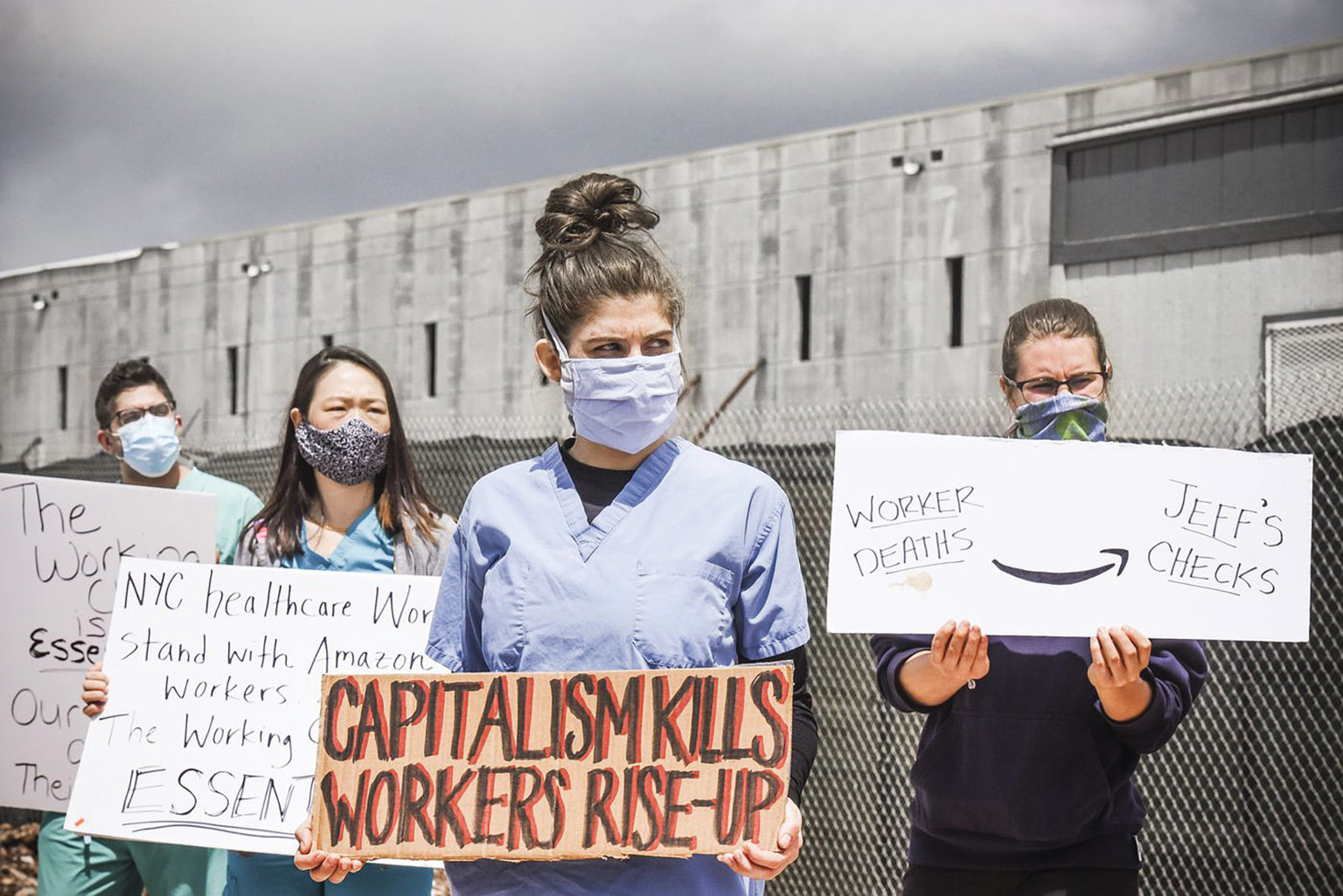 People standing with banners against capitalism and capitalization of healthcare